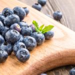 Freshly picked blueberries on wooden board
